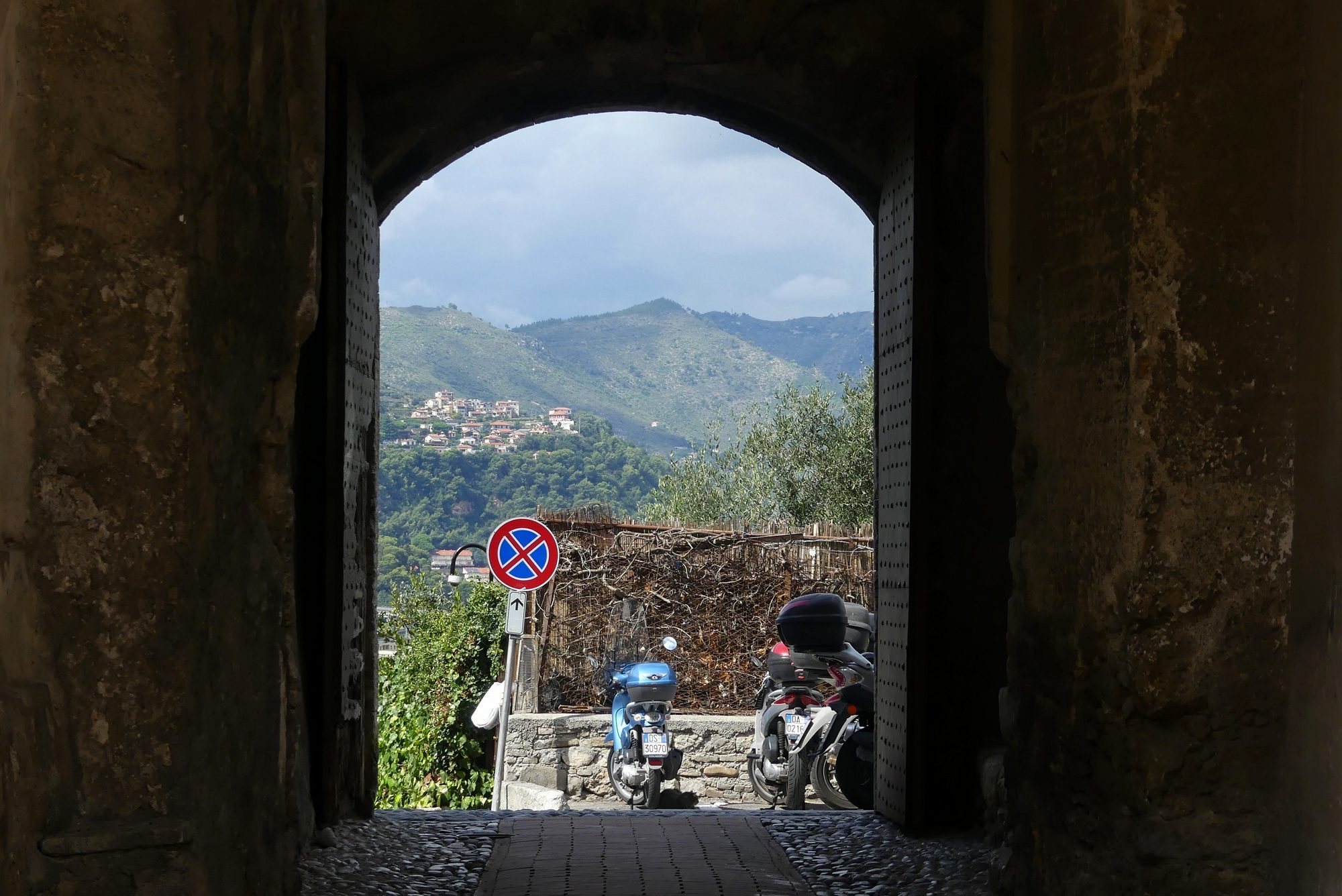 Blick auf die Berge durch ein Tor in der Altstadt von Ventimiglia Italien