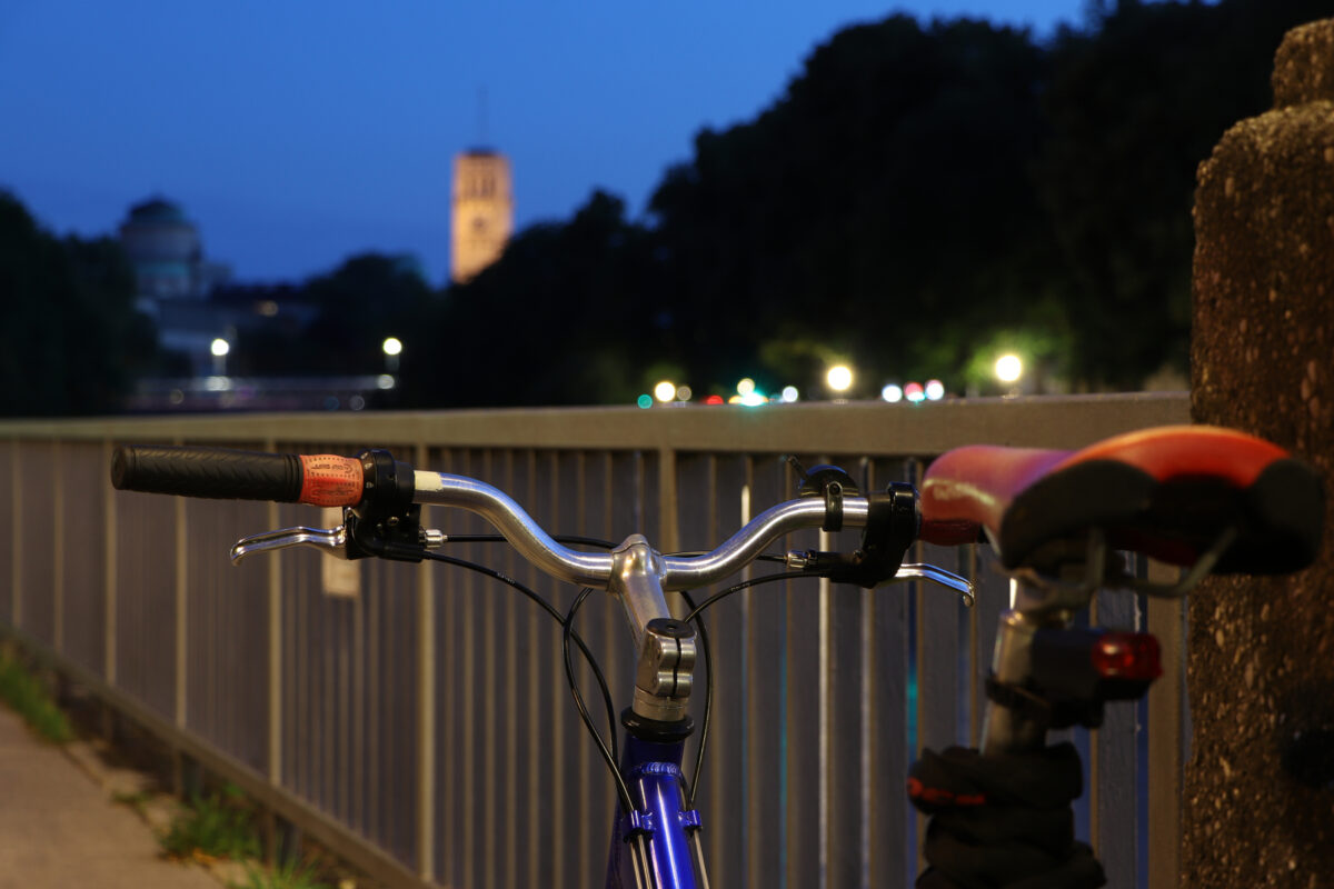 Fahrrad auf dem Wehrsteg an der Isar mit Blick auf das Deutsche Museum in München zur Blauen Stunde